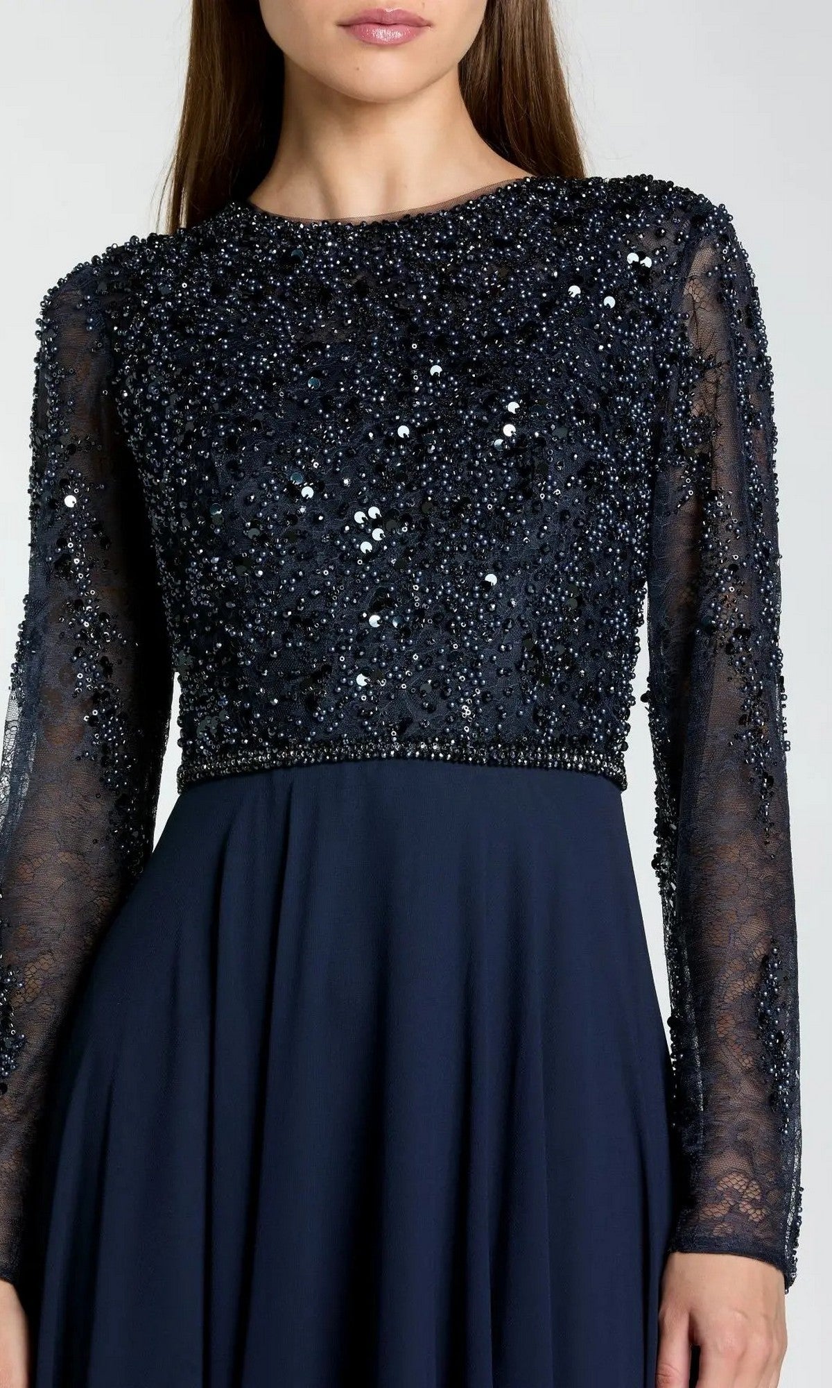 A woman models the Mac Duggal 21316 Long Formal Dress in navy, showcasing its sheer embellished bodice and flowing chiffon A-line skirt, shown from chest to knees against a plain background.